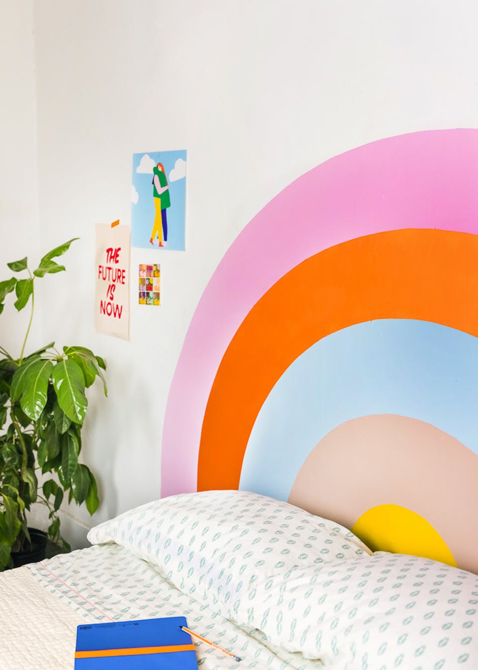 Kids bedroom DIY bright rainbow mural behind bed