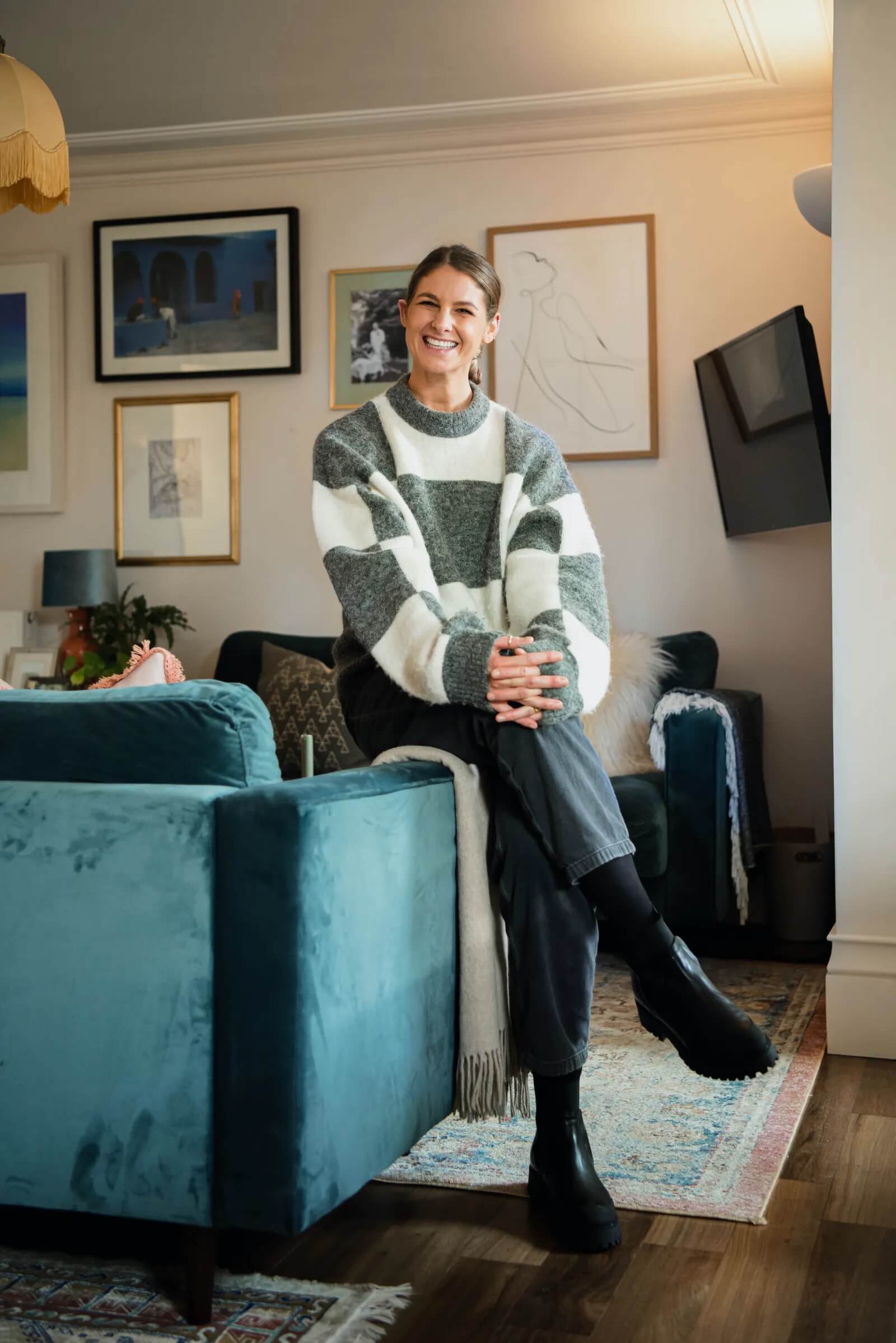 Tash Bradley smiling and sitting on a sofa