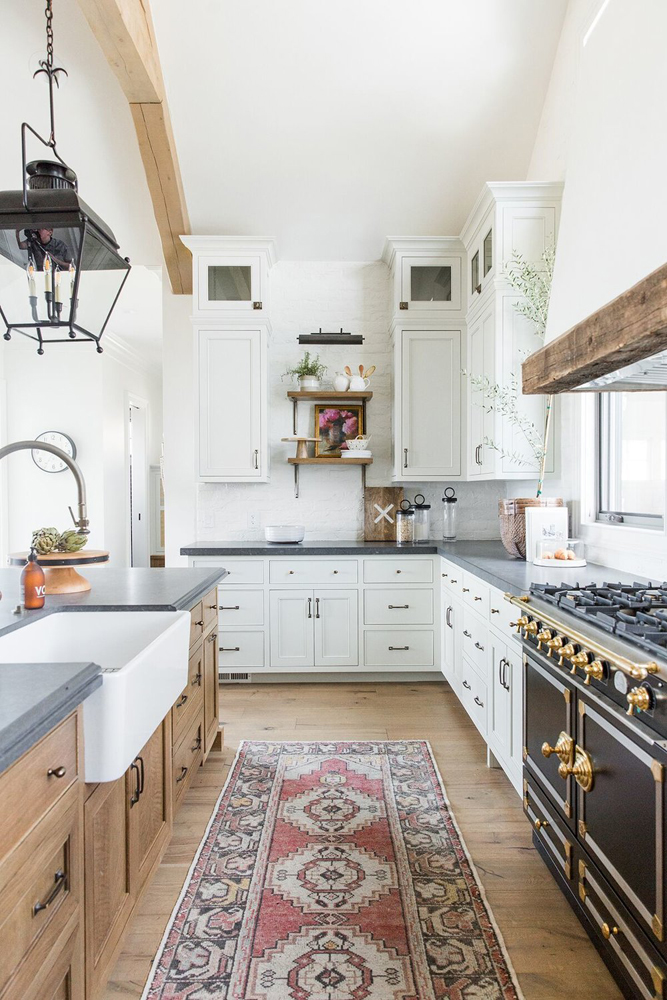 Moderne Bauernküche mit weißen und hölzernen Schränken über Amber Interior Design