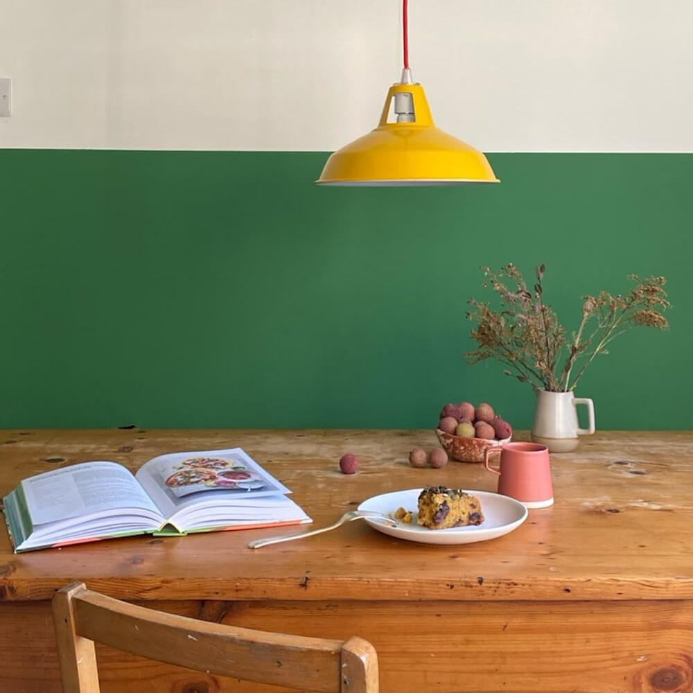 Dining room painted in Lick Green 07 with a yellow pendant lamp above the table