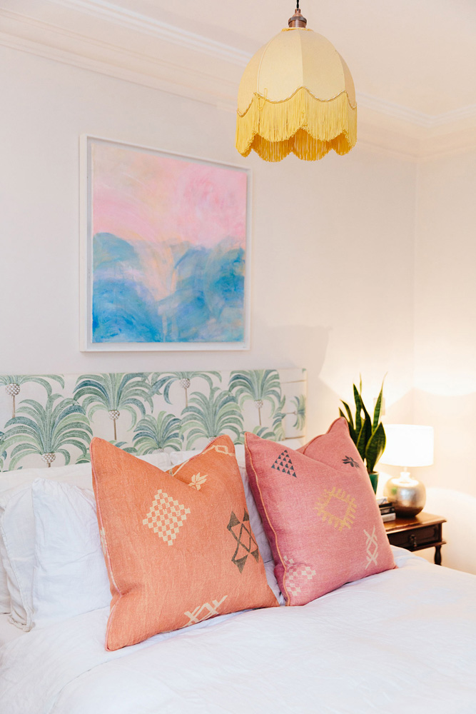 Bedroom painted in Lick Pink 01 with a patterned upholstered headboard