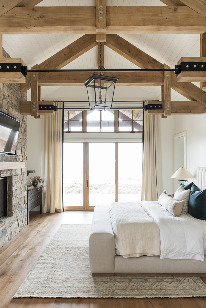 Modern farmhouse bedroom with exposed wooden beams by Studio McGEE
