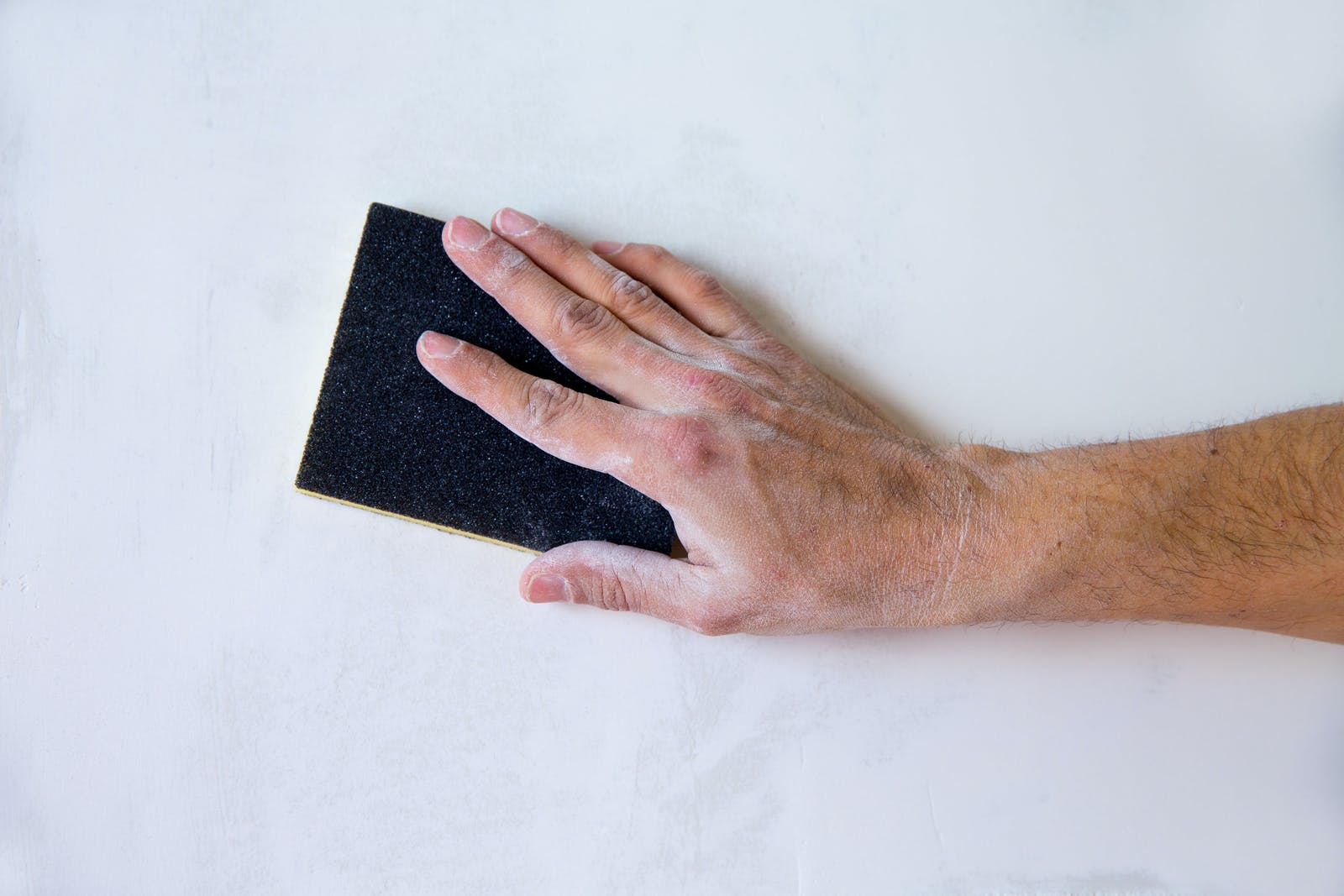 Man sanding walls