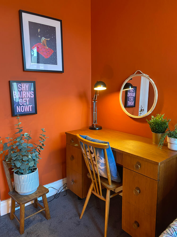 Desk area with orange painted walls
