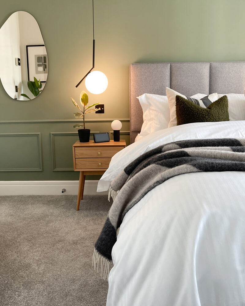 Upholstered headboard in bedroom painted in Lick Green 02 paint