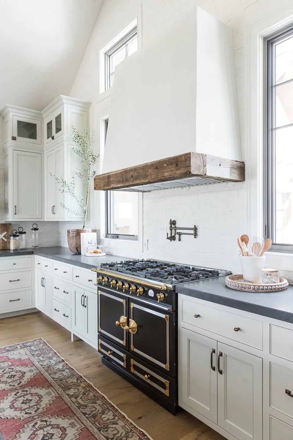 Modern farmhouse kitchen with a traditional gas stove by Studio McGee