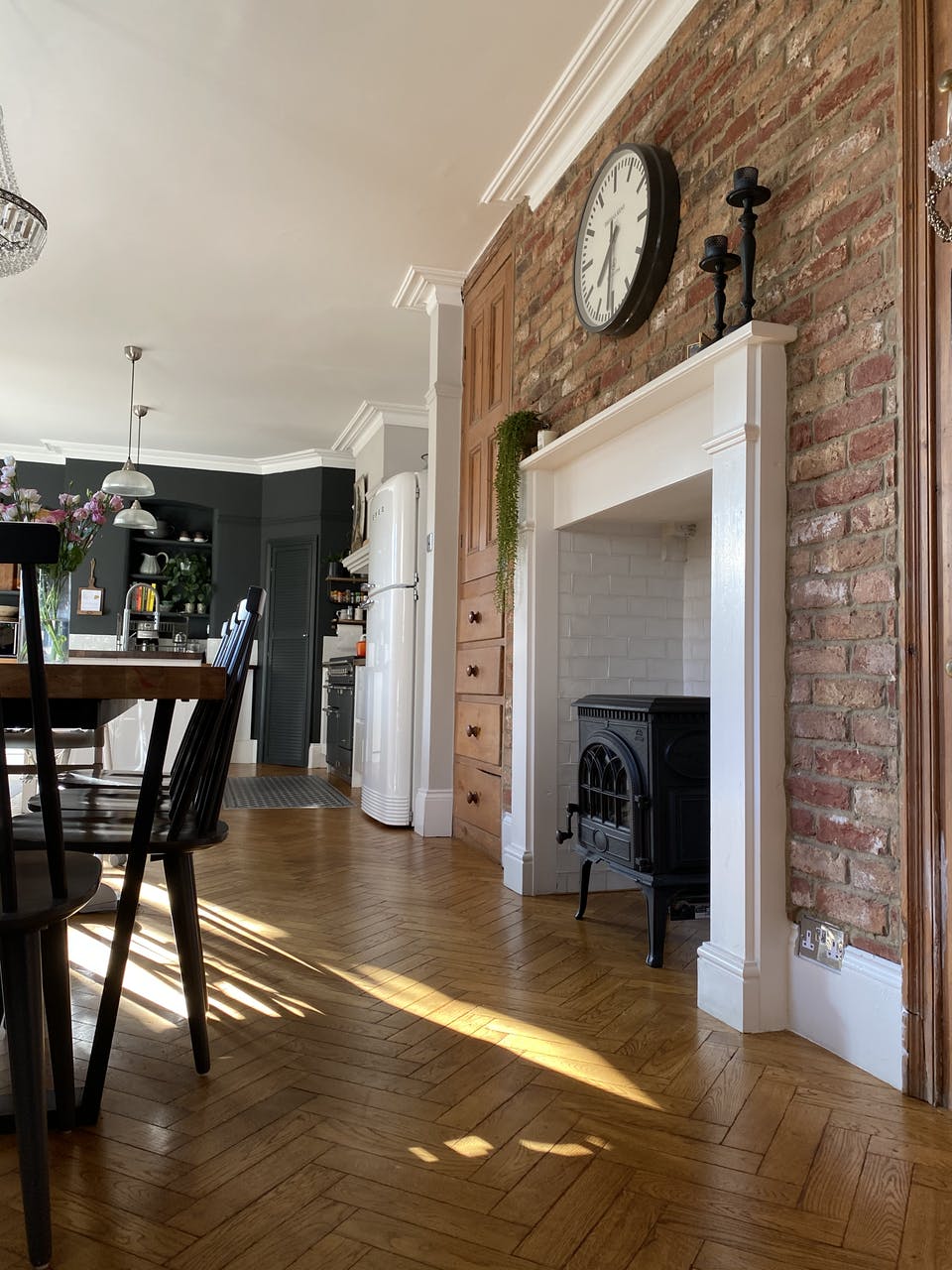 Dining room with rustic brick wall, original fireplace and herringbone flooring