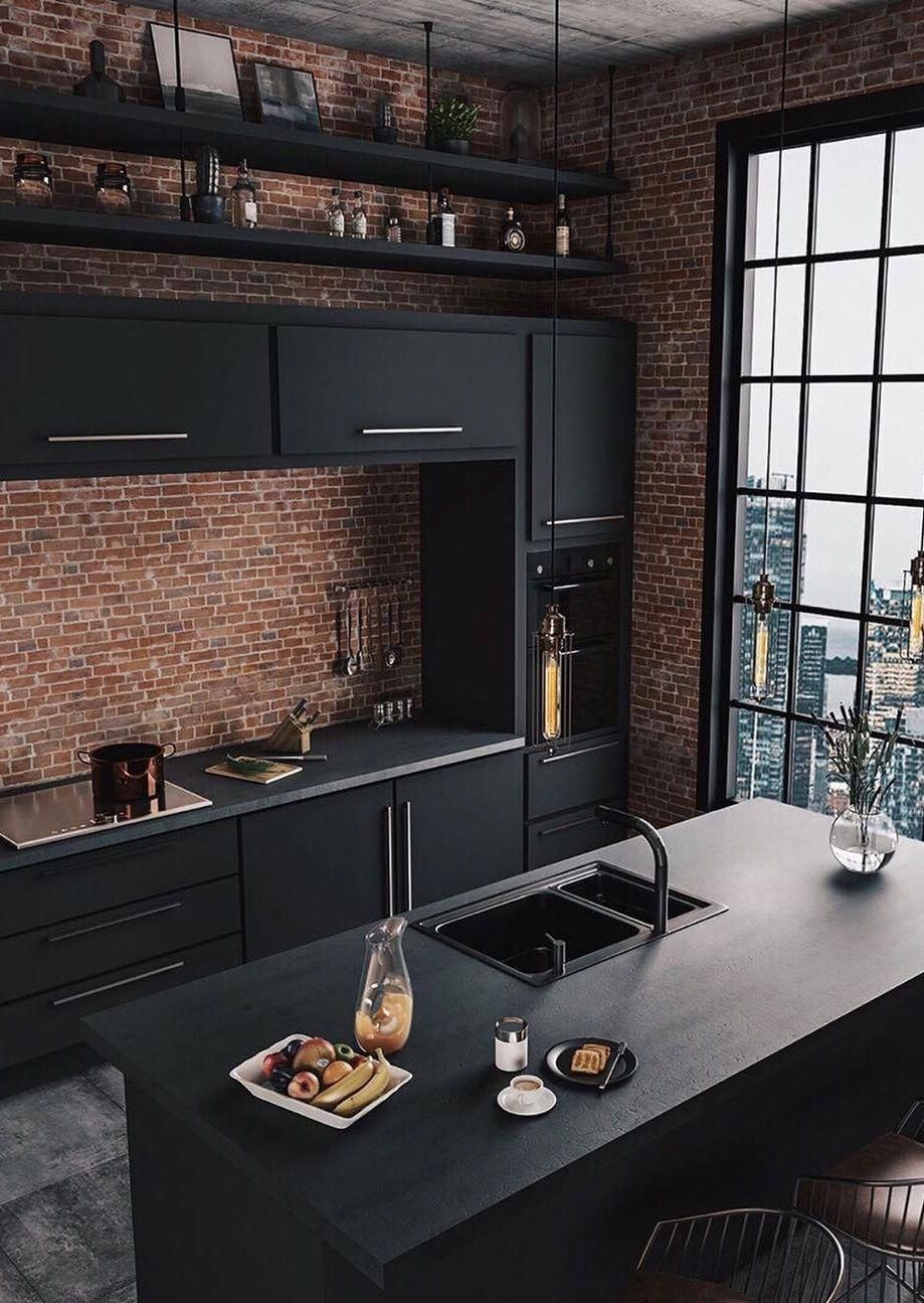 Black kitchen with gold accents and exposed brick walls 