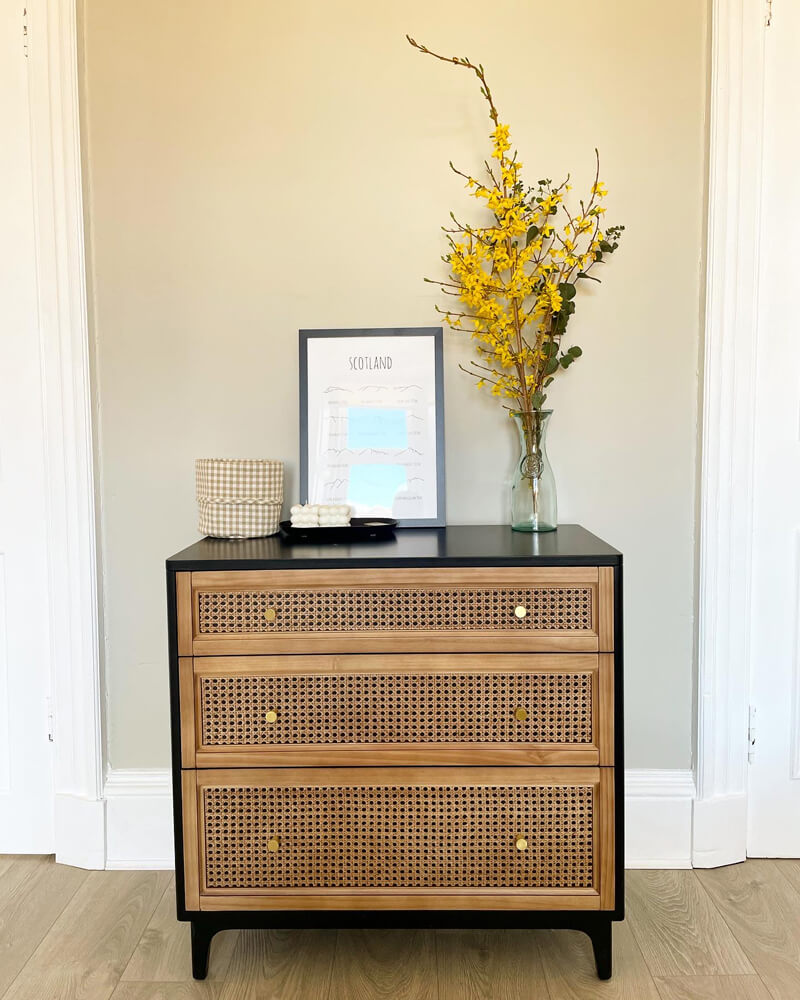 Rattan chest of drawers with dried flowers in vase
