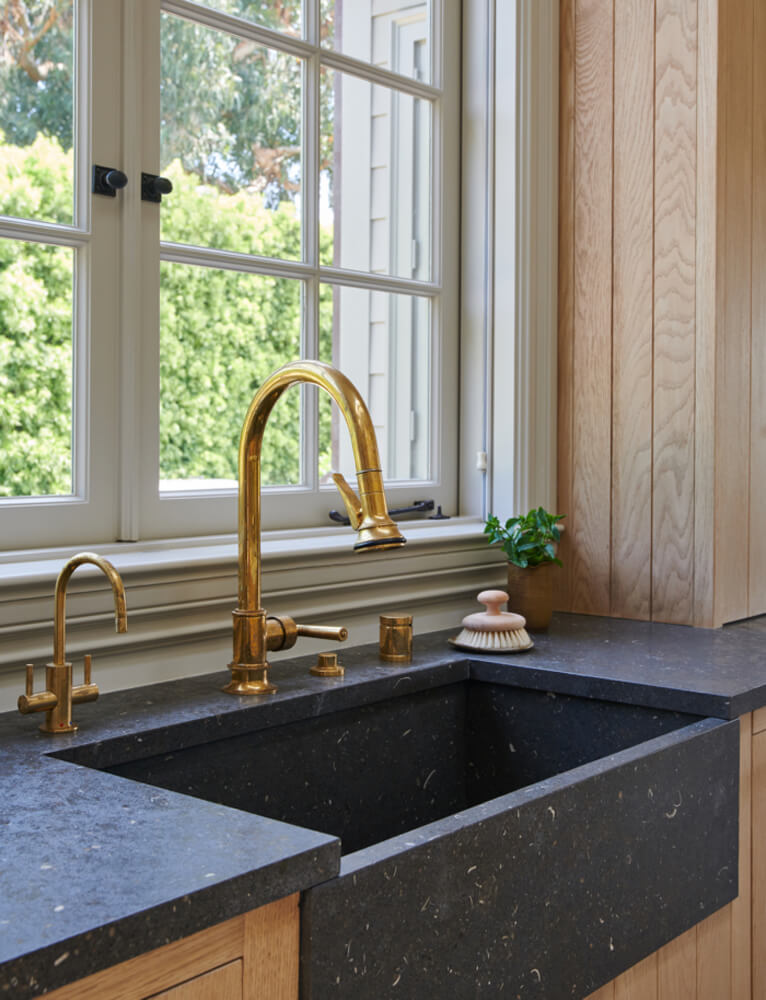 Moderne Bauernhaus-Spüle aus schwarzem Granit mit goldenem Wasserhahn von Amber Interior Design