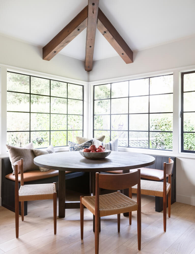 Modern farmhouse dining room with large windows and a round table photographed by Jess Isaac via Amber Interior Design