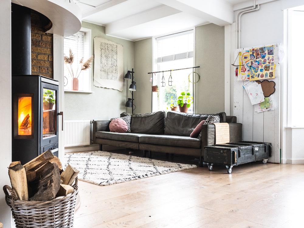 Industrielles Wohnzimmer mit dunklem Ledersofa und Ottoman
