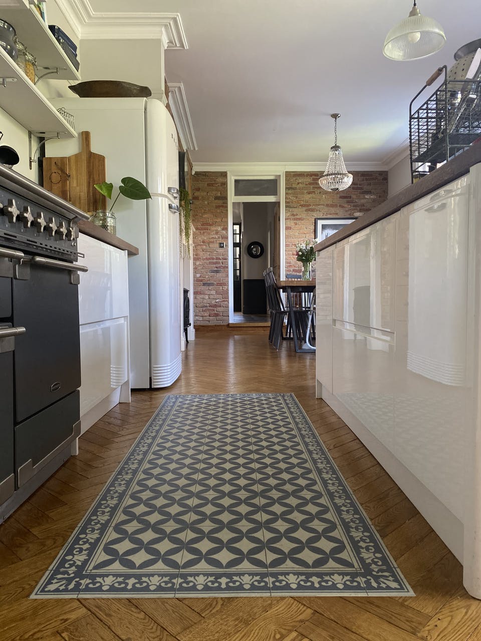 Galley white gloss kitchen with herringbone flooring