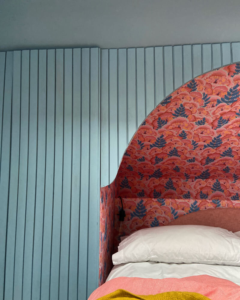 A DIY headboard using batten panelling decorated in Lick Blue 04 and a wallpaper feature wall using Lick Electric poppies 01 wallpaper