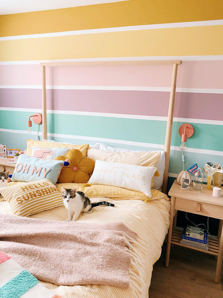 A feature wall in a bedroom painted in Lick paint colours, including Yellow 02