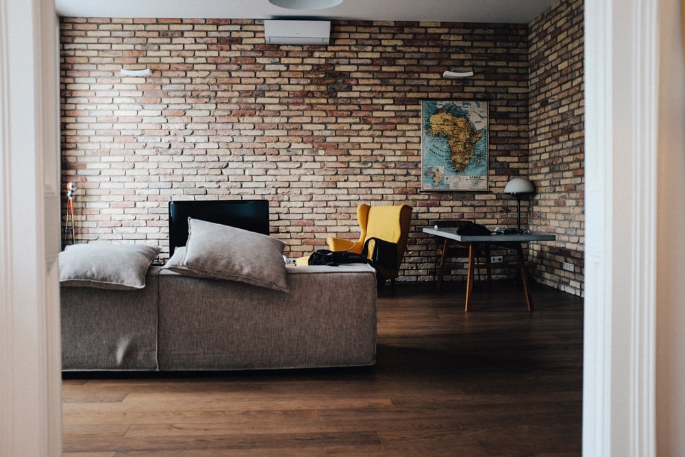 Exposed brick living room with grey couch