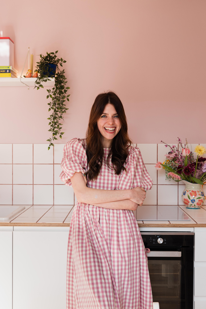 Lindsey Isla in her kitchen painted in Lick Pink 03 paint