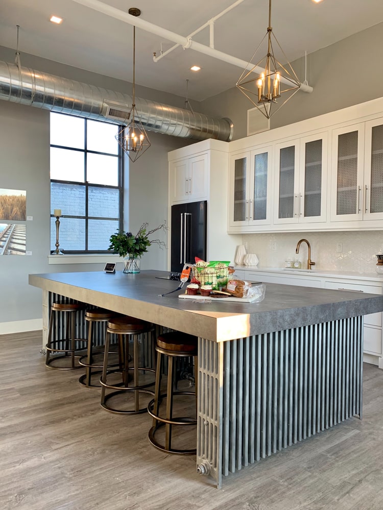 White and grey kitchen with large black fridge