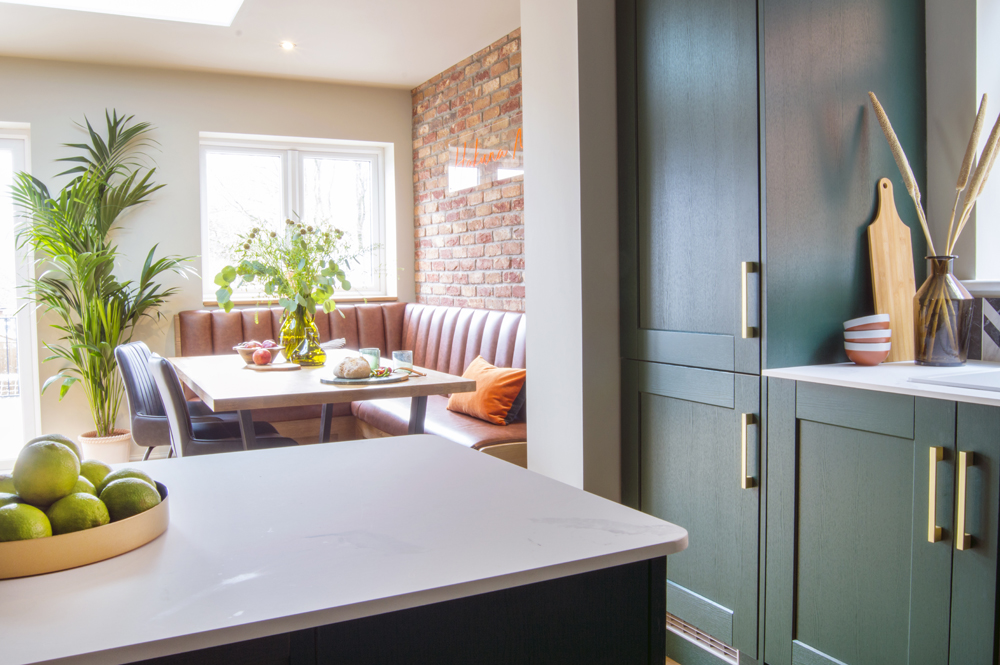 Industrial kitchen with green cabinets and gold accents