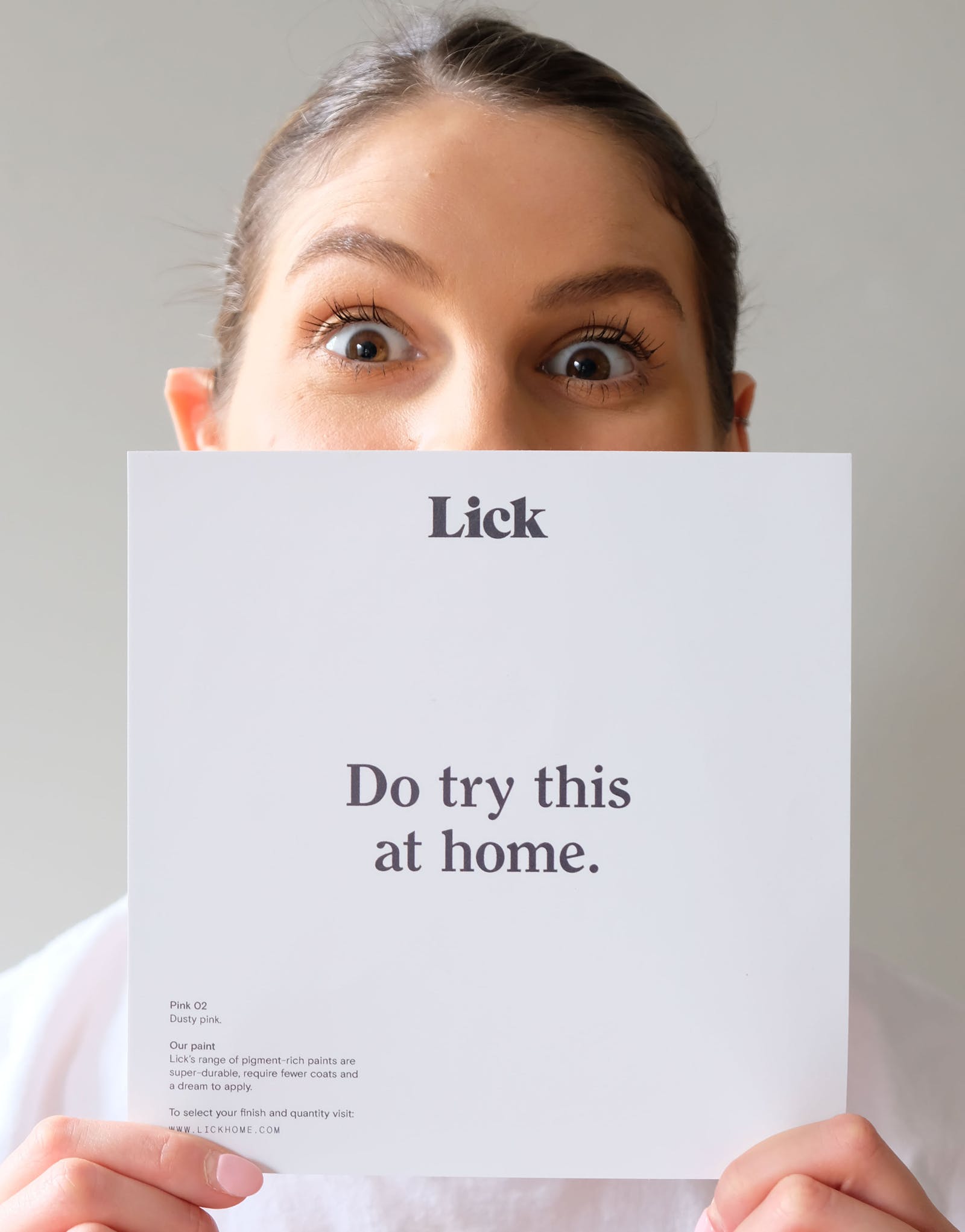 Tash Lick's lead colour expert holding a card that says 'do try this at home'