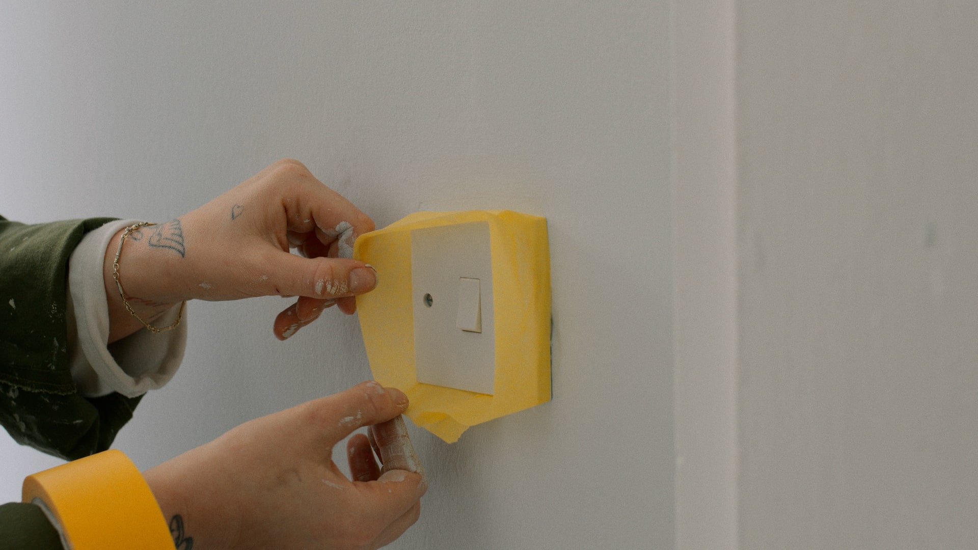 Masking painters tape being used to cover a light switch