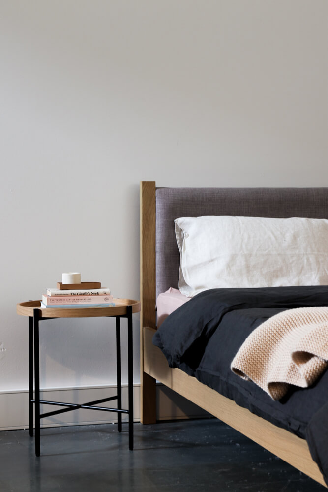 A modern bedroom with dark bedding and furnishings 