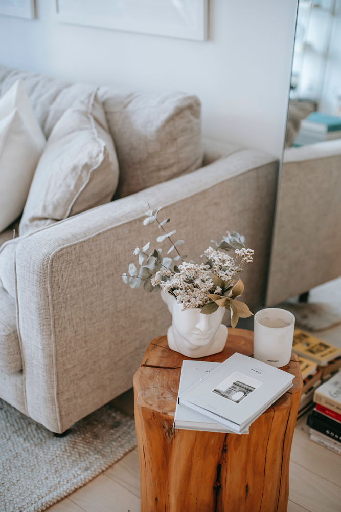 Grey sofa with white furnishings on side table