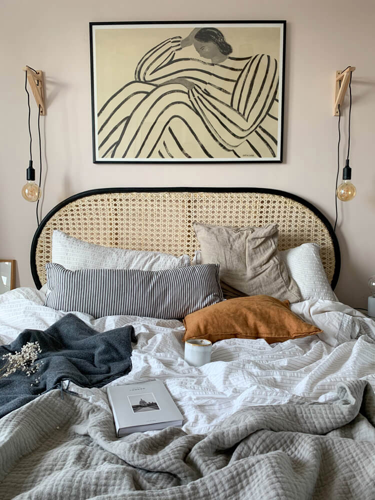 Bedroom painted in Lick Pink 01 with a rattan headboard