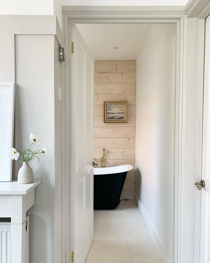 Modern farmhouse bathroom with a black bathtub and minimal decor by @simplyscandikatie