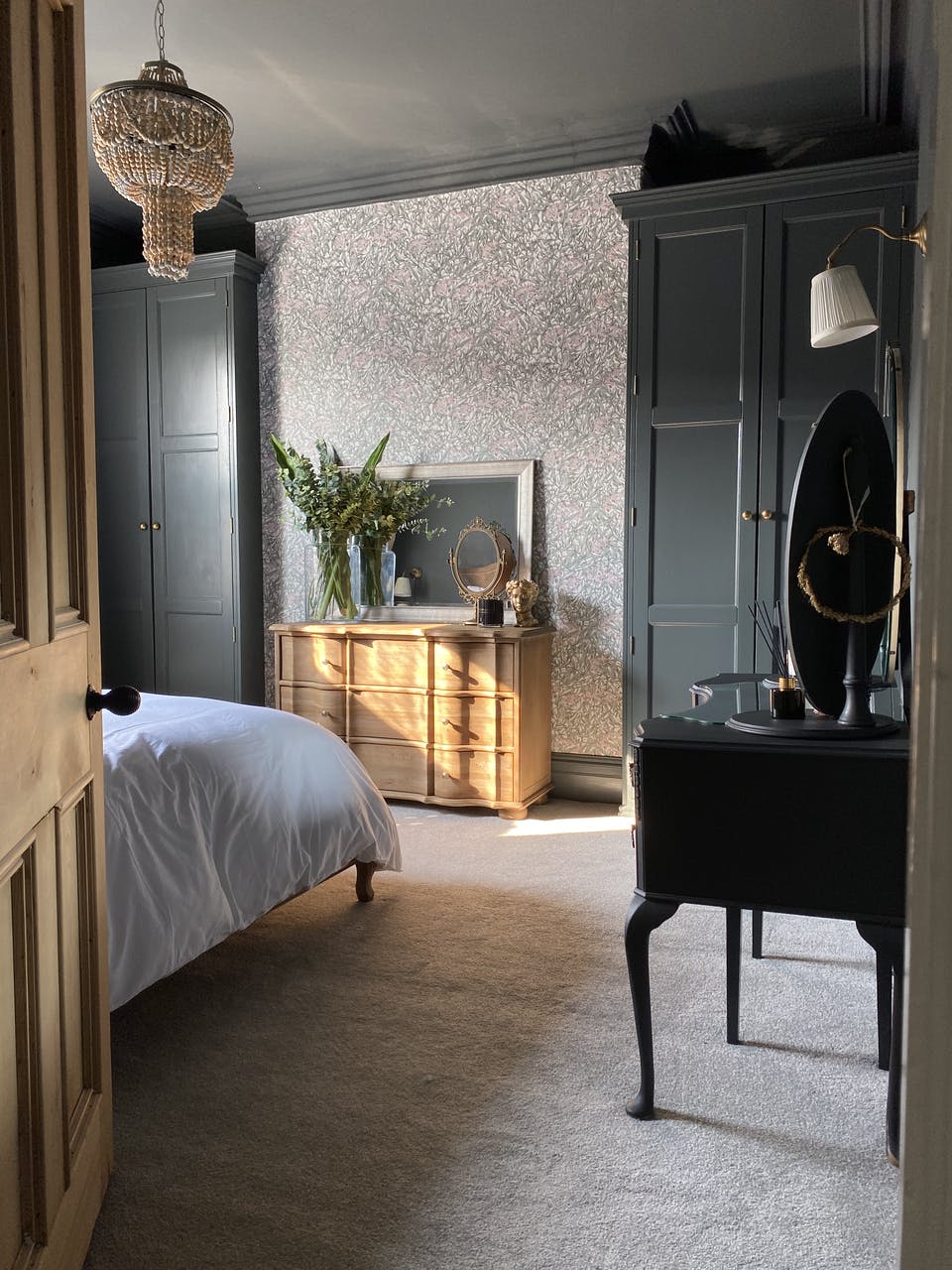 Neutral tones with wood finishes bedroom with black panelled wardrobes